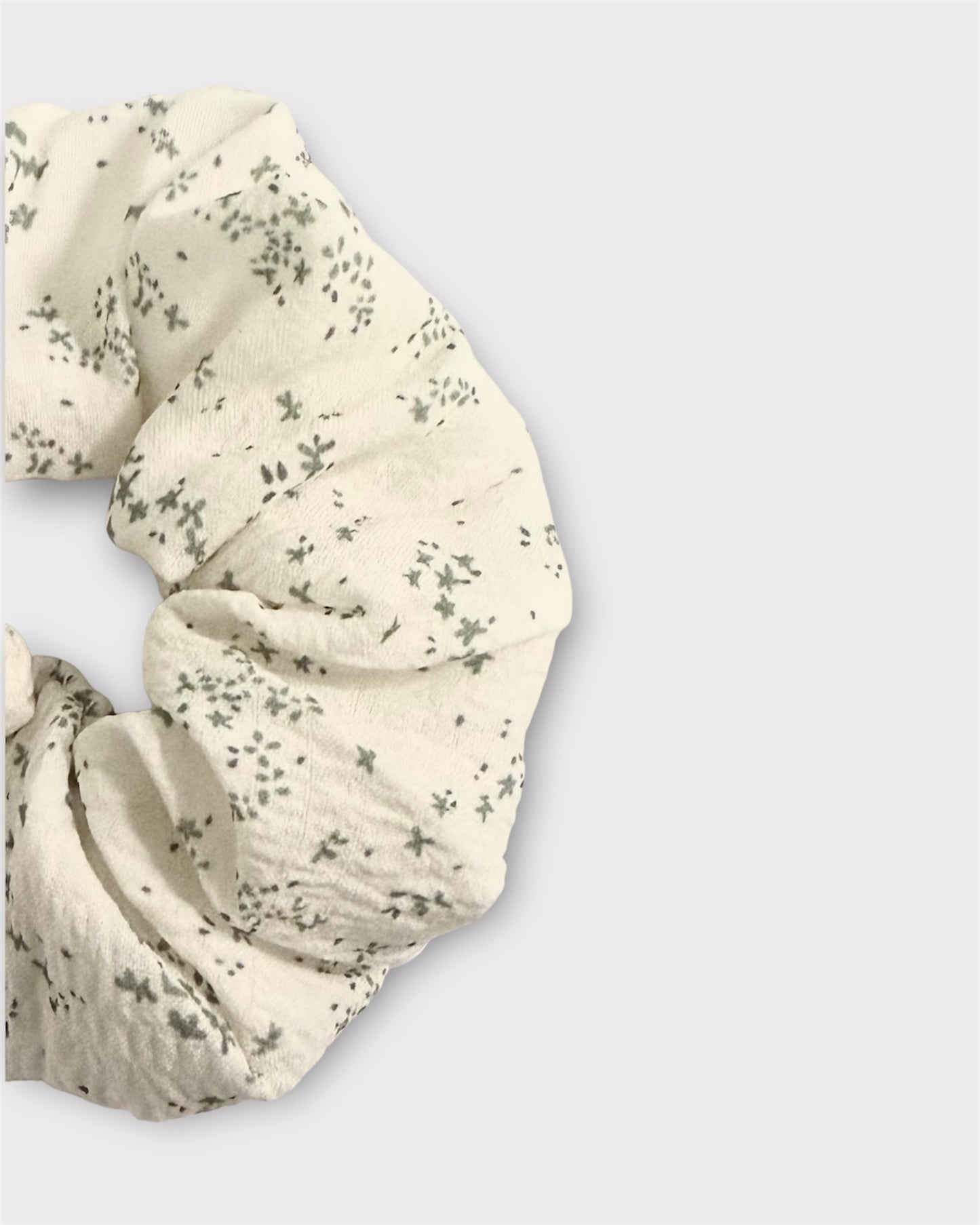 White scrunchie with subtle pattern on a light gray background