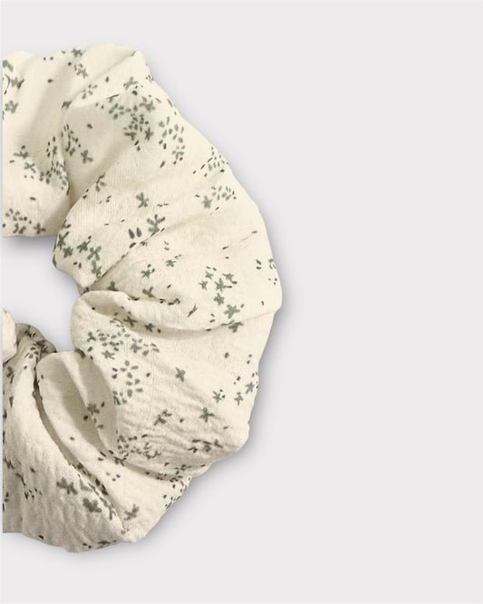 White scrunchie with subtle pattern on a light gray background