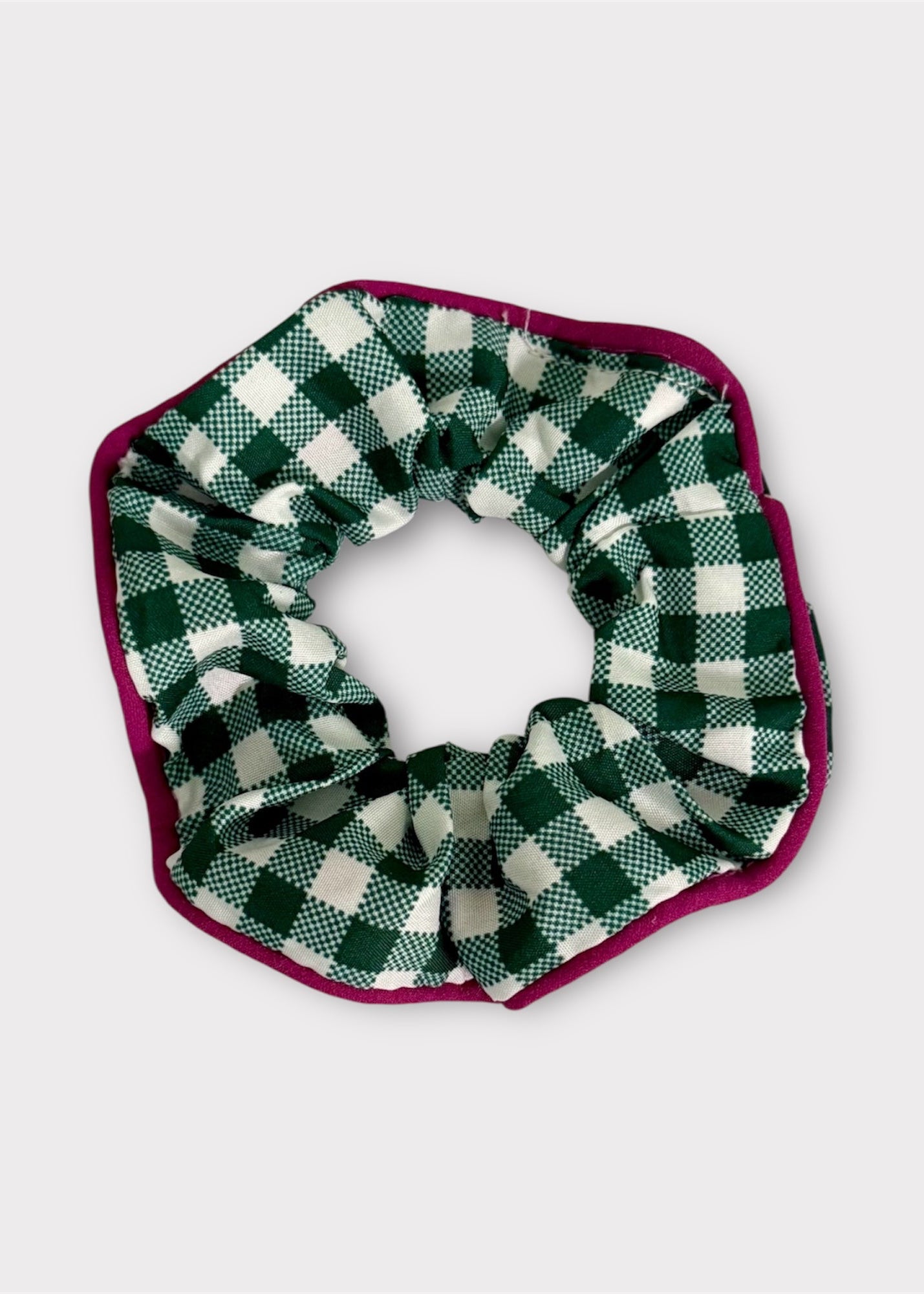 Green and white checkered scrunchie with a purple border on a light gray background