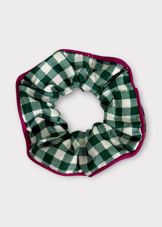 Green and white checkered scrunchie with a purple border on a light gray background